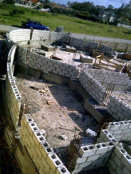 Aerial view of curved foundation block walls with rebar, early construction stage