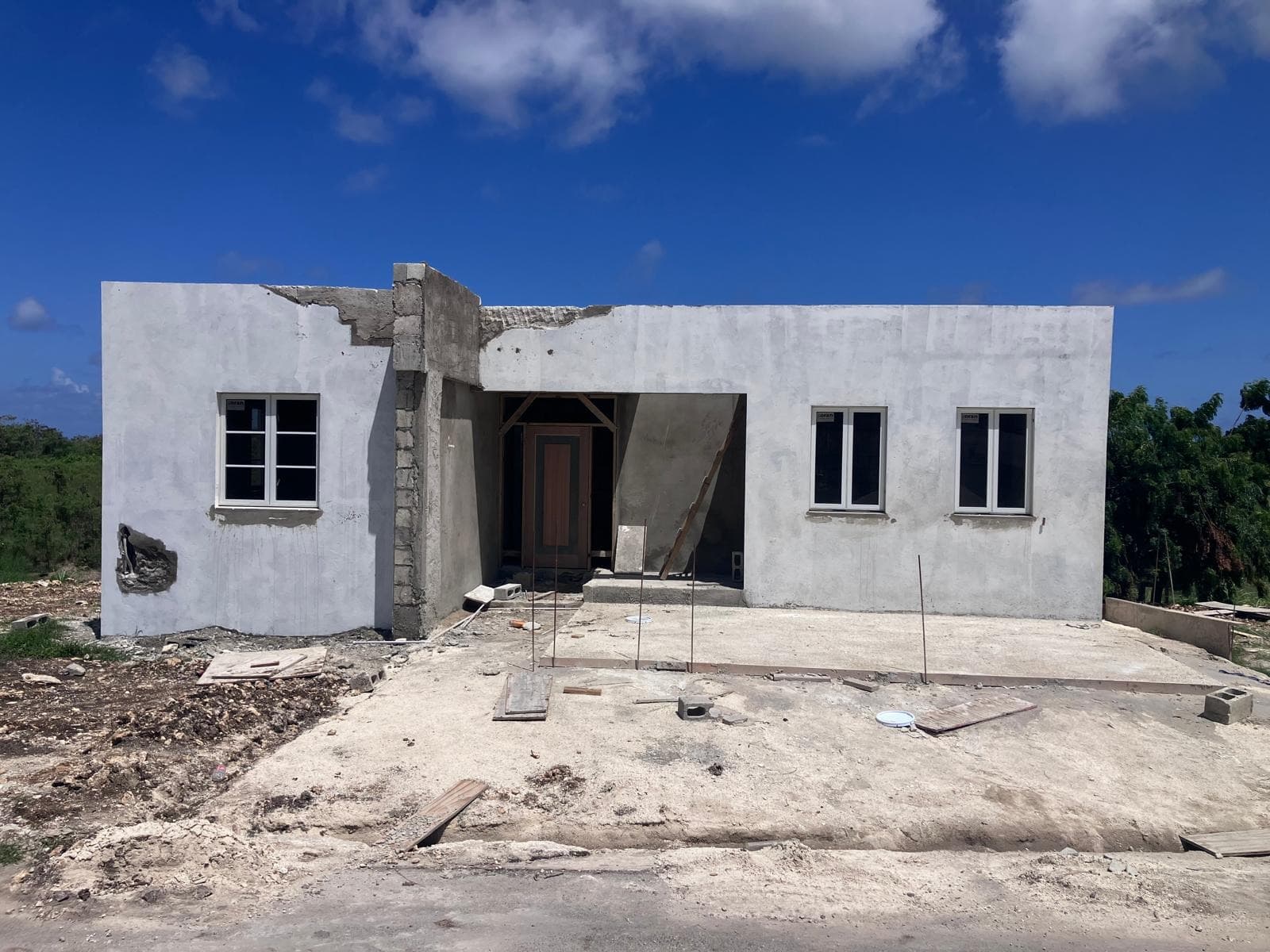 Front elevation of a plastered residence shell with door installed