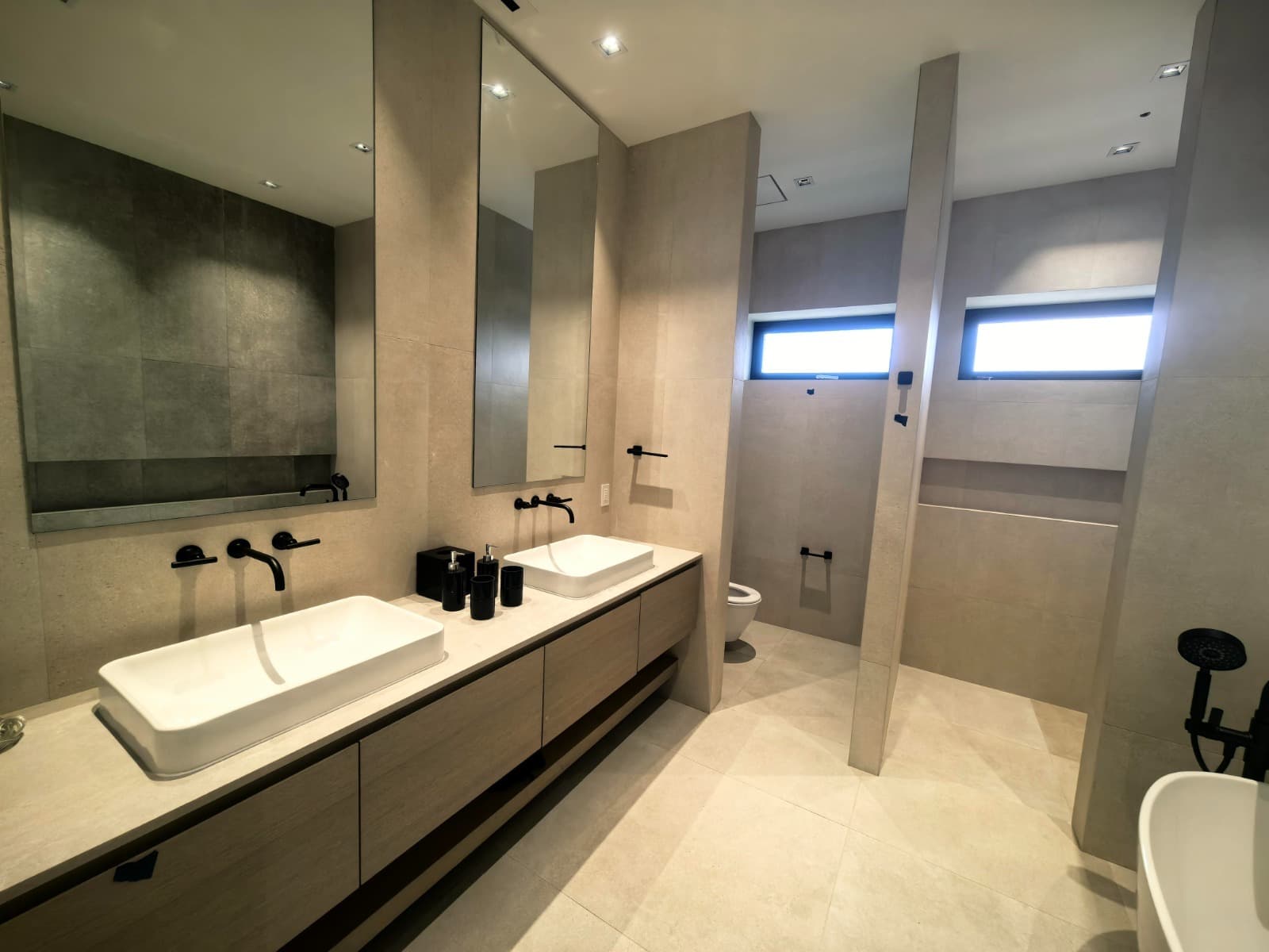 Large wet-room style bathroom with freestanding tub and glass shower enclosure
