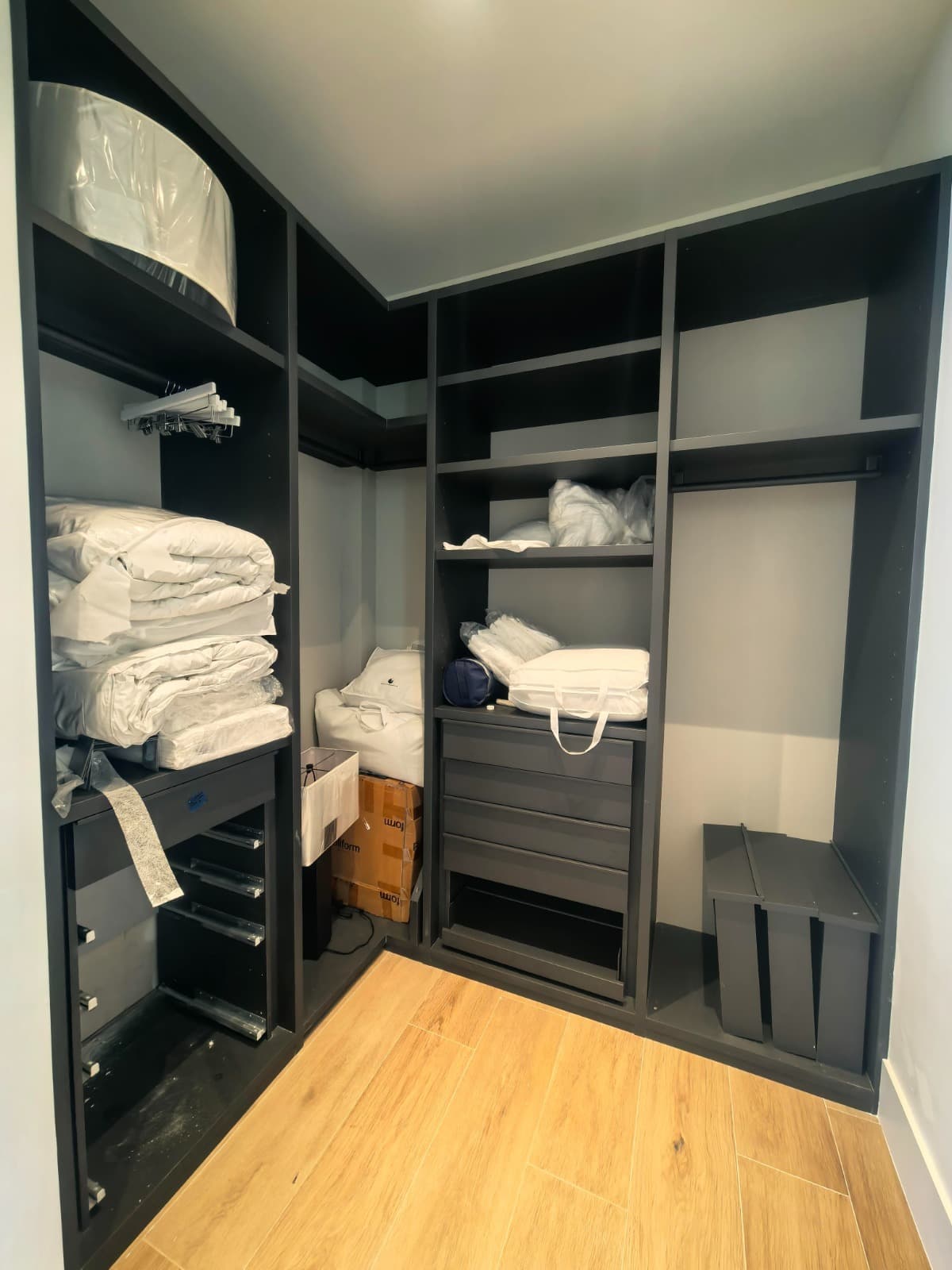 Walk-in closet storage nearing completion, linens and fittings staged