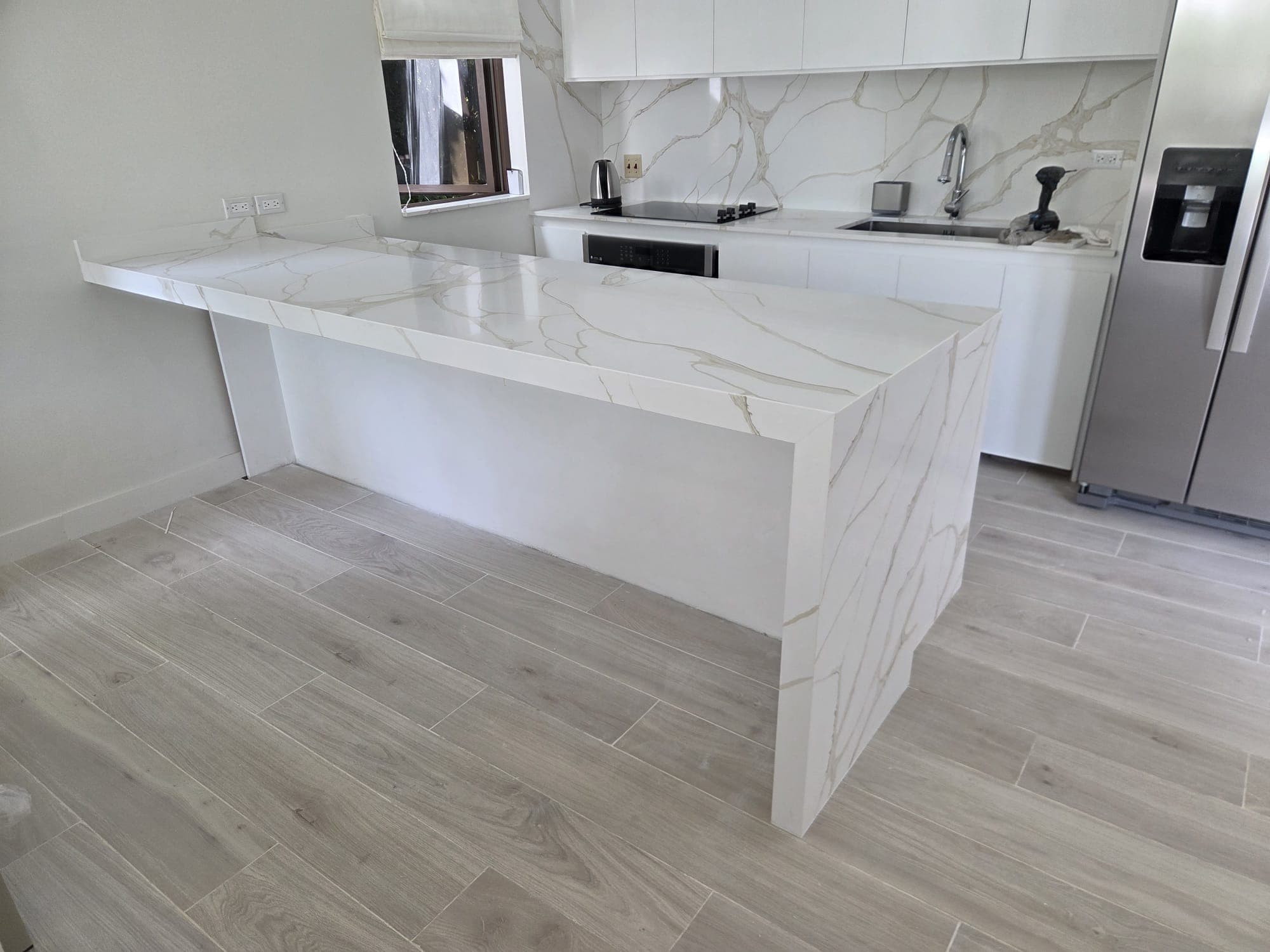 White marble kitchen island in a near-complete residence
