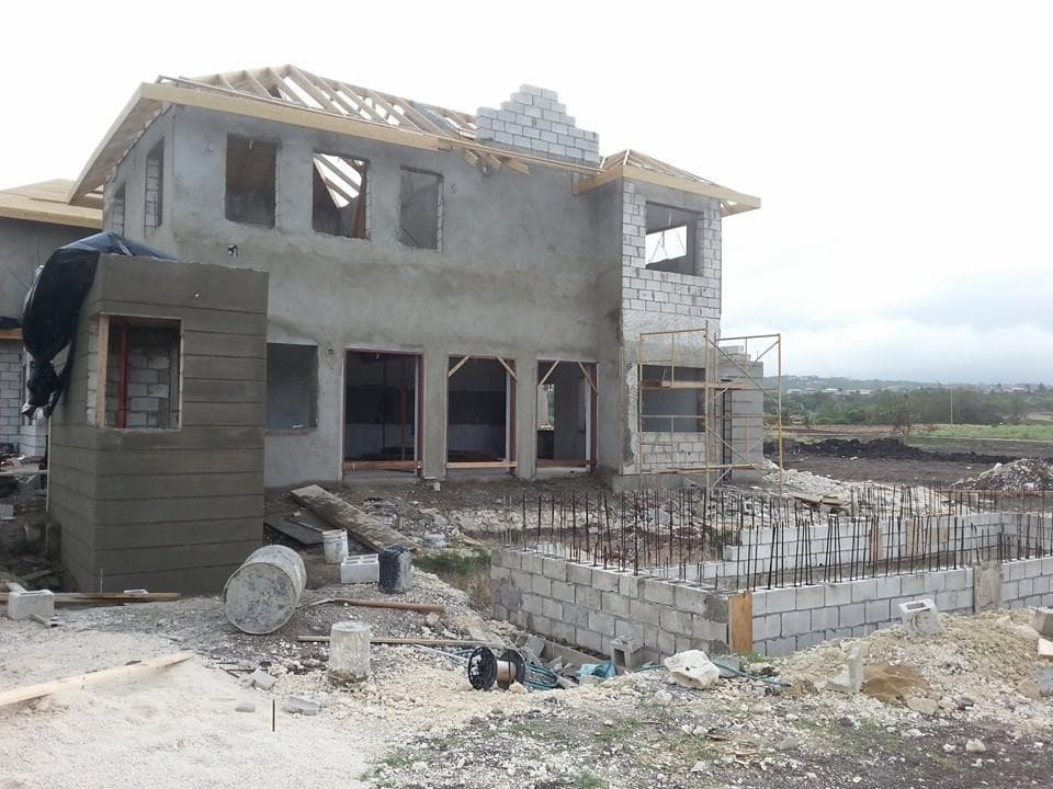 Two-storey residence with roof framing nearly complete and scaffolding still in place