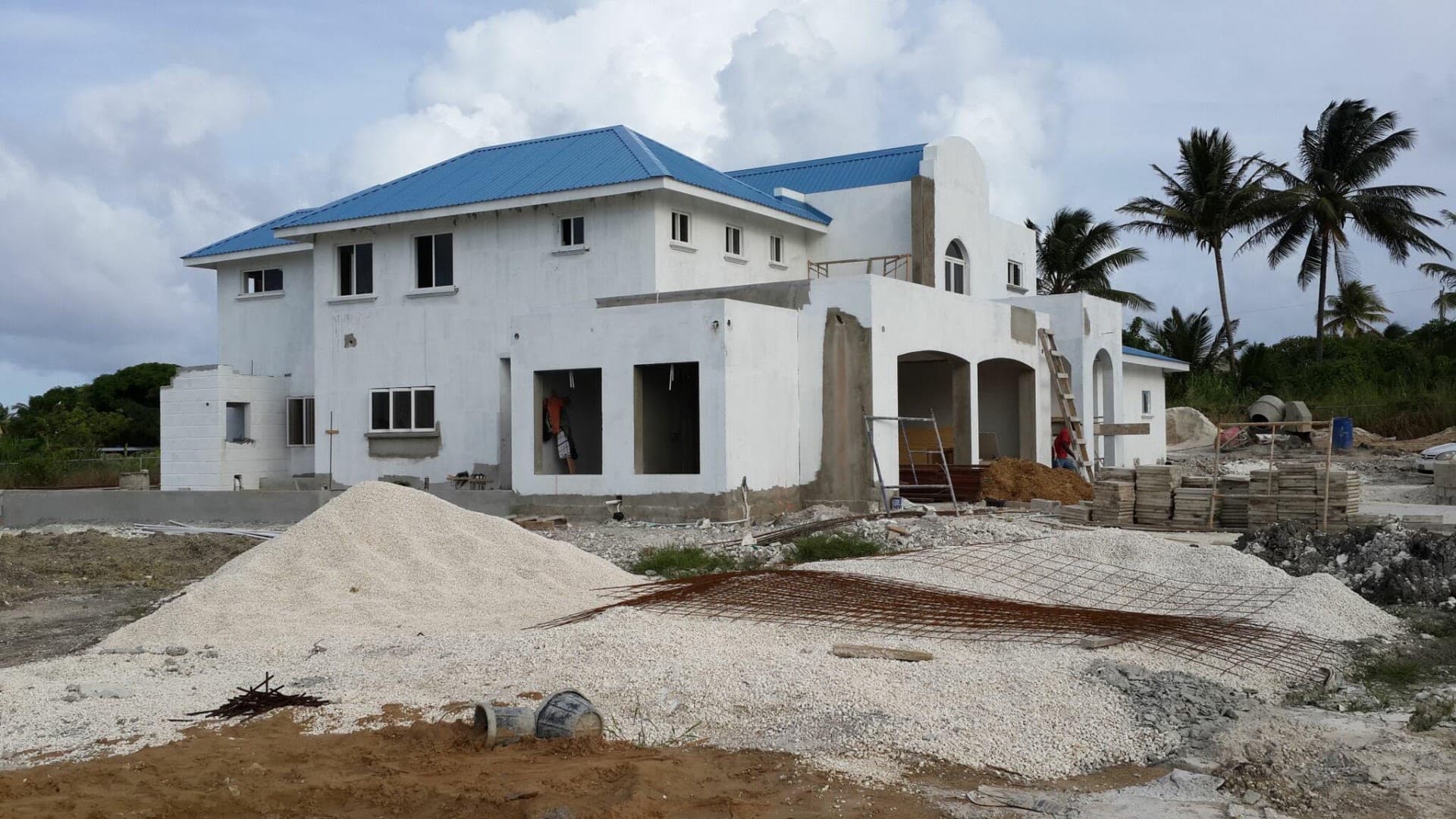 Completed coastal residence with blue metal roof, built under design-build delivery