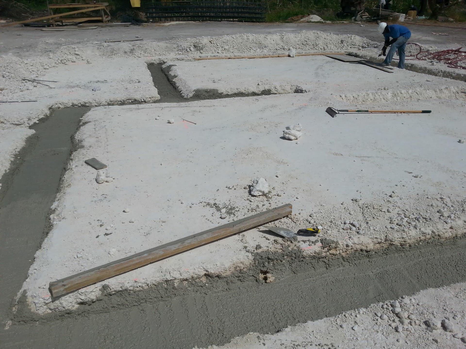 Worker finishing a concrete footing and slab edge on site