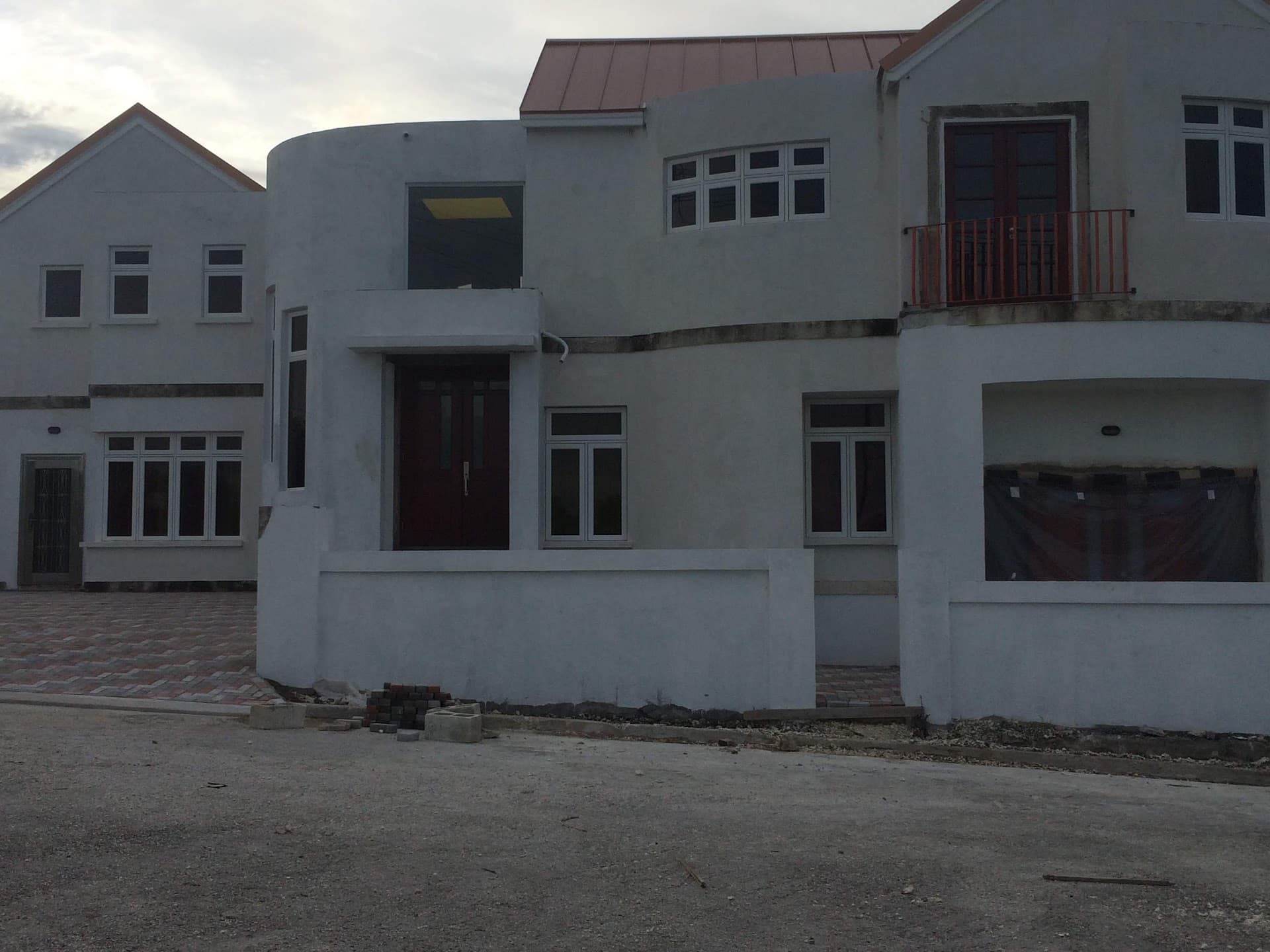 Rendered two-storey residence near completion, photographed at dusk