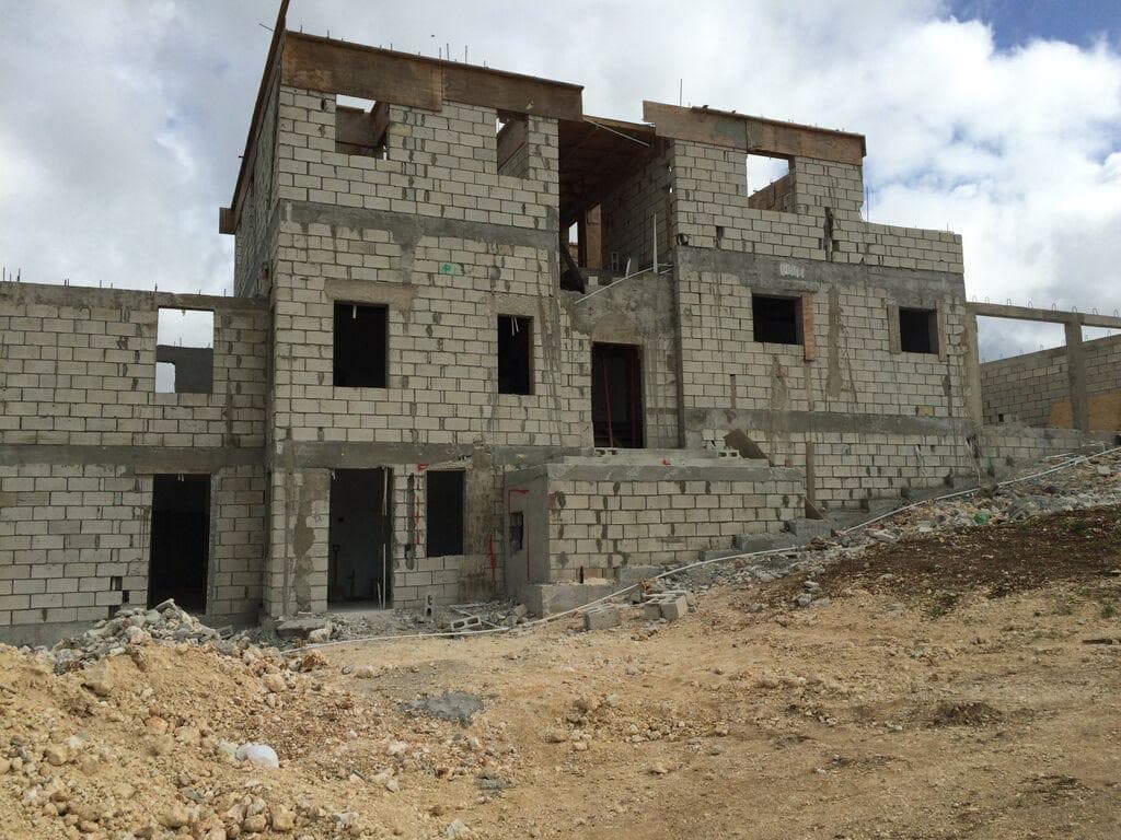 Concrete block structural shell of a house with timber roof deck framing