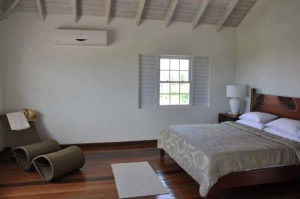 Bedroom with exposed timber ceiling and air-conditioning unit