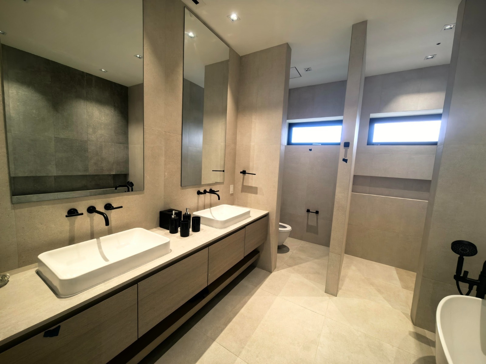 Large wet-room style bathroom with freestanding tub and glass shower enclosure