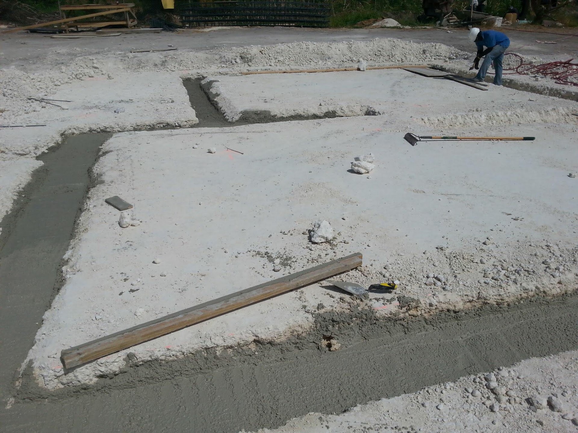 Worker finishing a concrete footing and slab edge on site