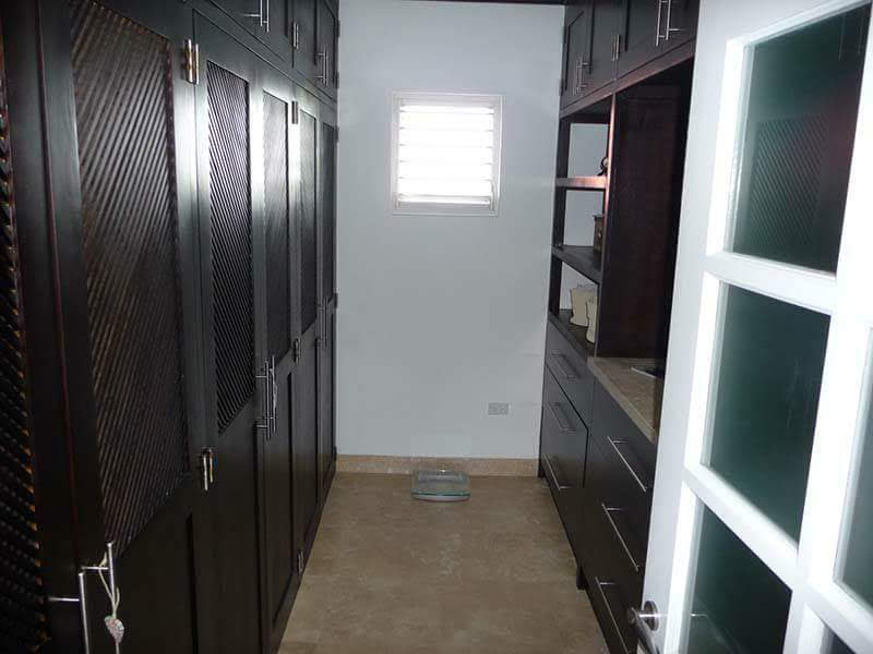 Walk-in dressing room with dark timber cabinetry