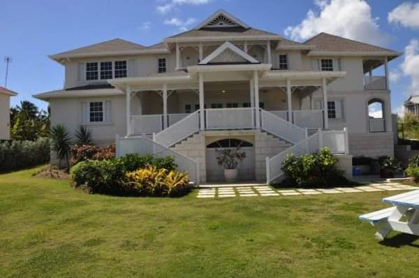 Completed white luxury residence exterior with landscaped front lawn