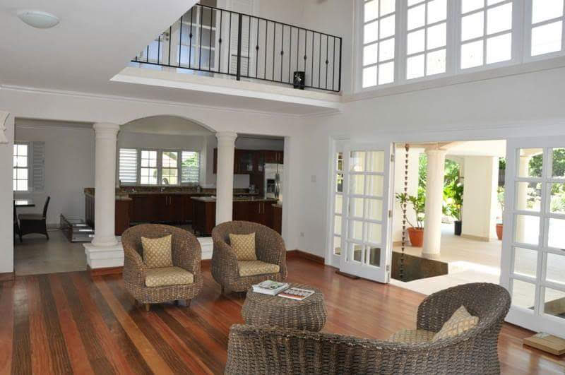 Living room with double-height mezzanine and wicker furniture