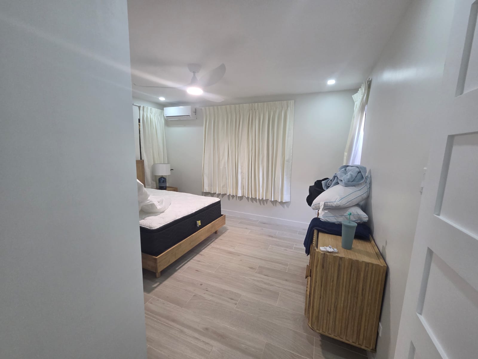 Renovated bedroom with wood-look flooring and ceiling fan
