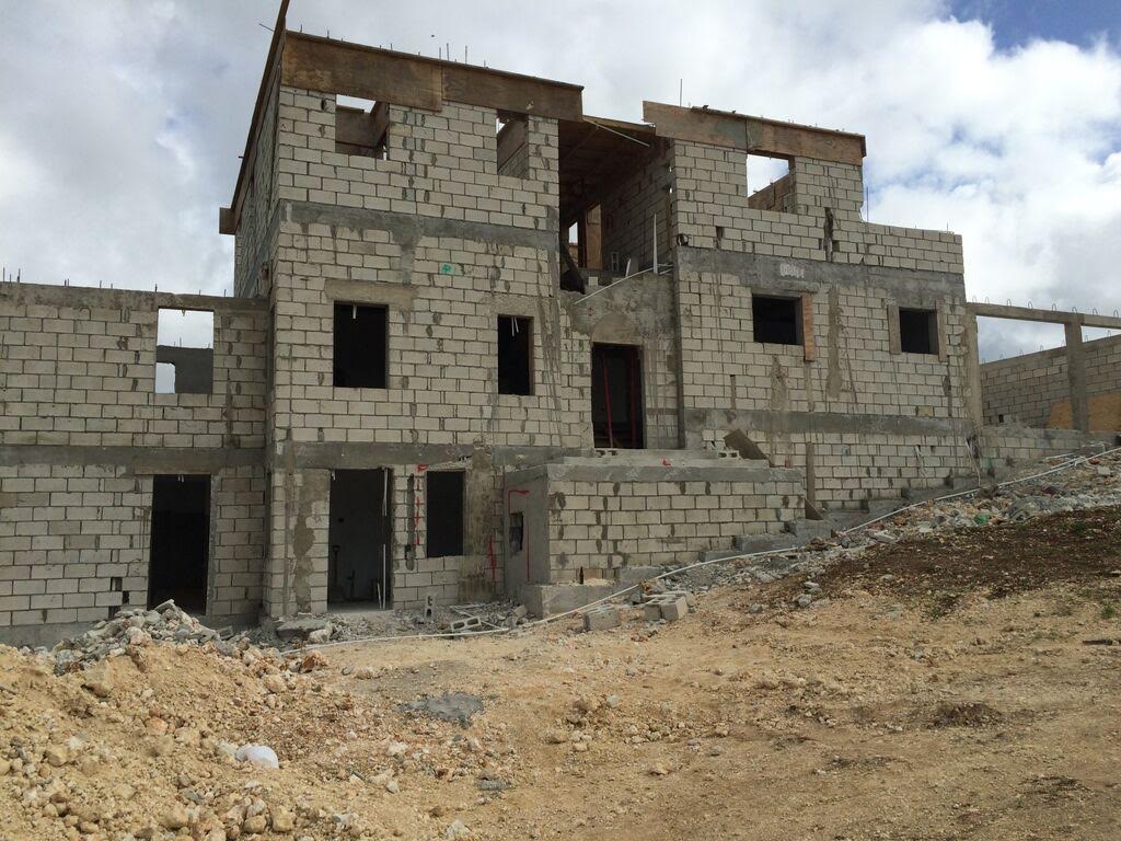 Concrete block structural shell of a house with timber roof deck framing