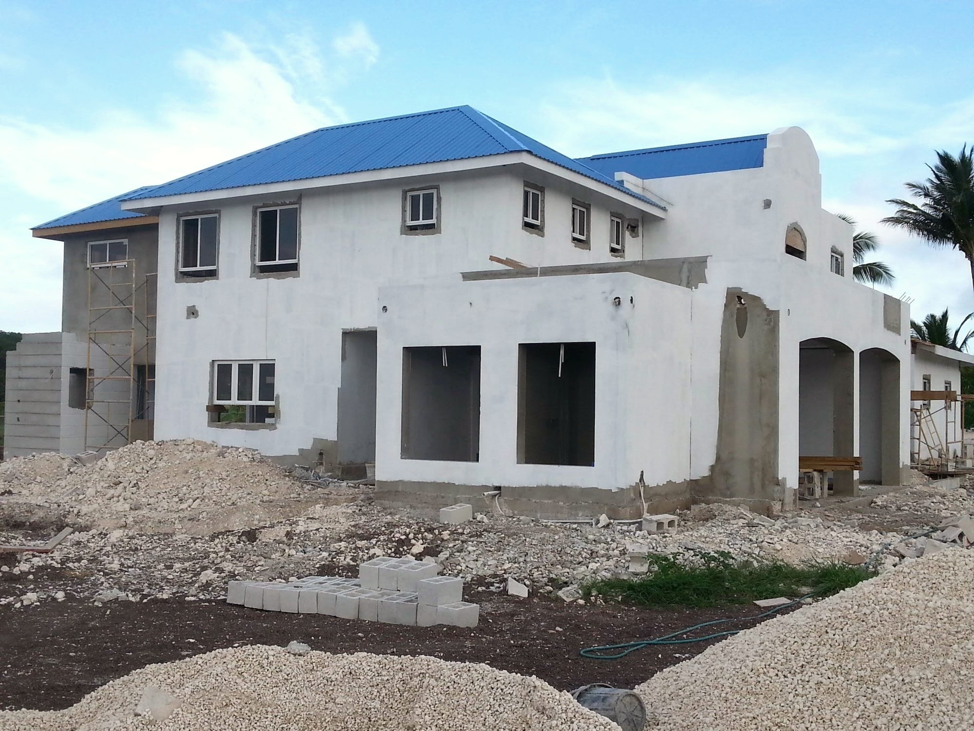 Completed two-storey residence with blue metal roof and white rendered exterior