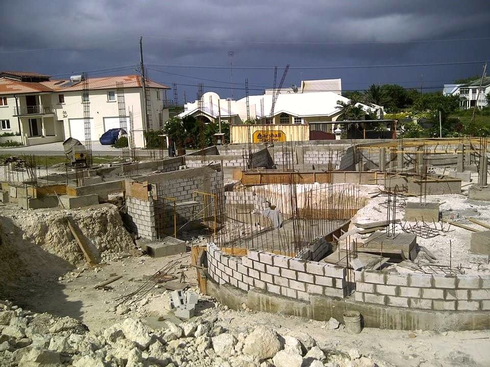 Actual construction photograph: curved blockwork foundation under construction matching the design concept
