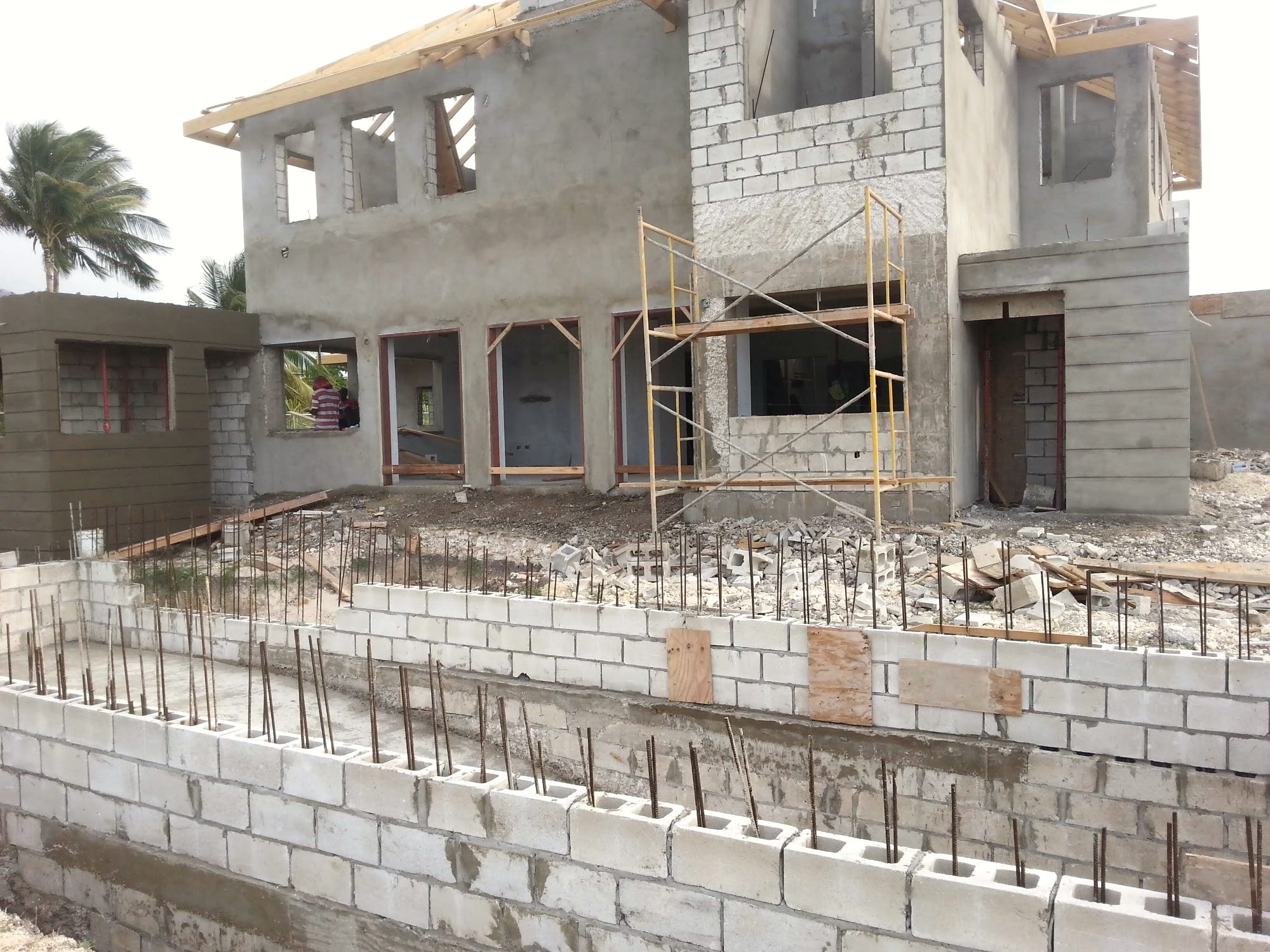 Structural shell nearing completion, blue metal roof visible