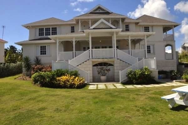Completed grand colonial-style residence with symmetrical twin staircase entrance