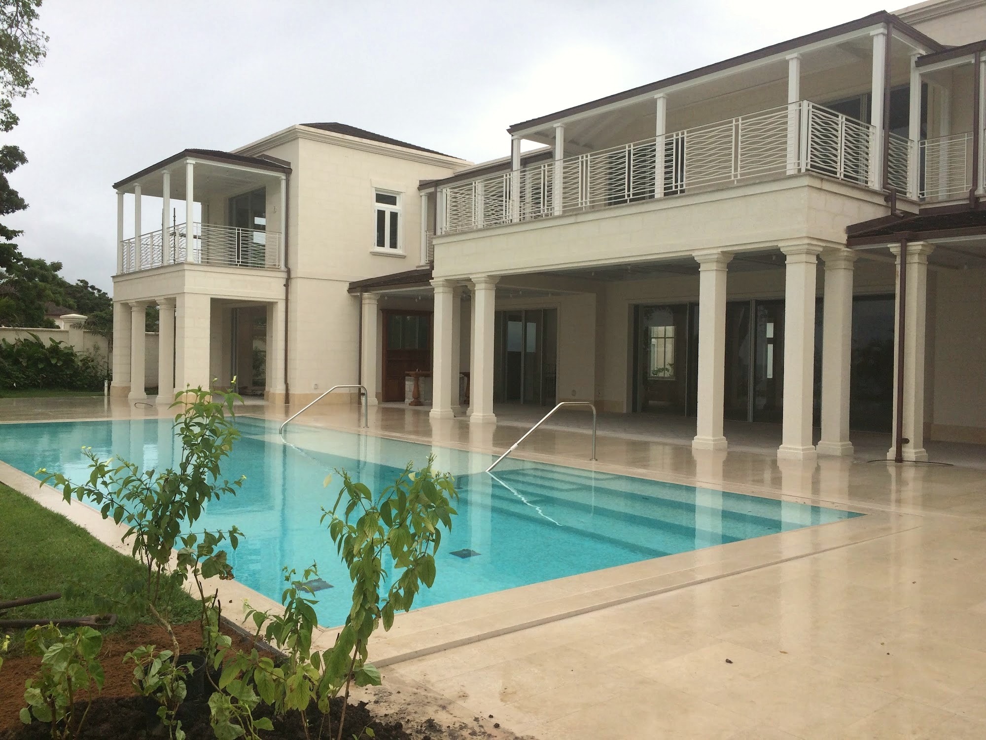 Completed two-storey residence with colonnaded terrace overlooking an infinity-edge pool