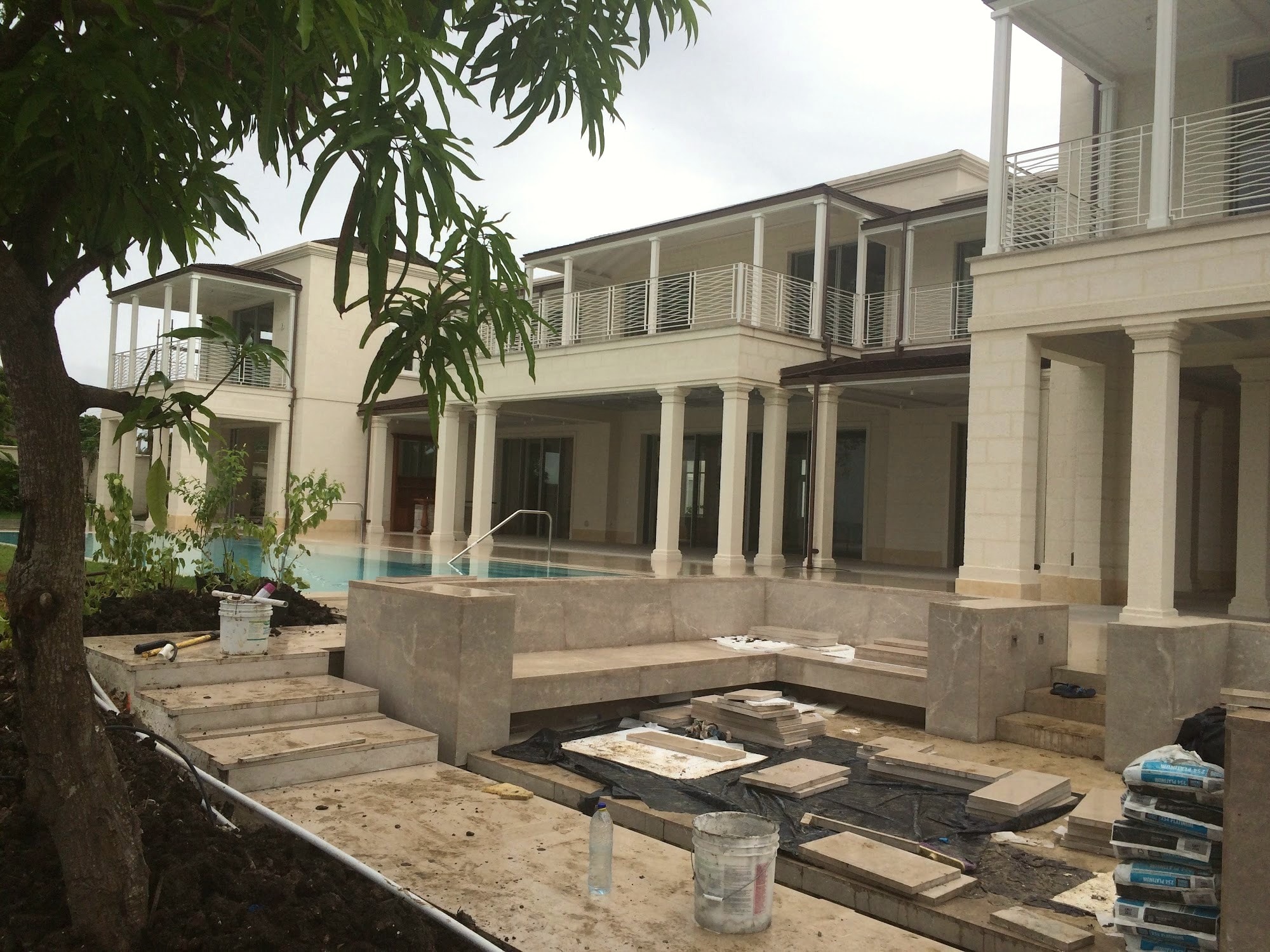 Residence terrace and infinity-edge pool, partially shaded by trees