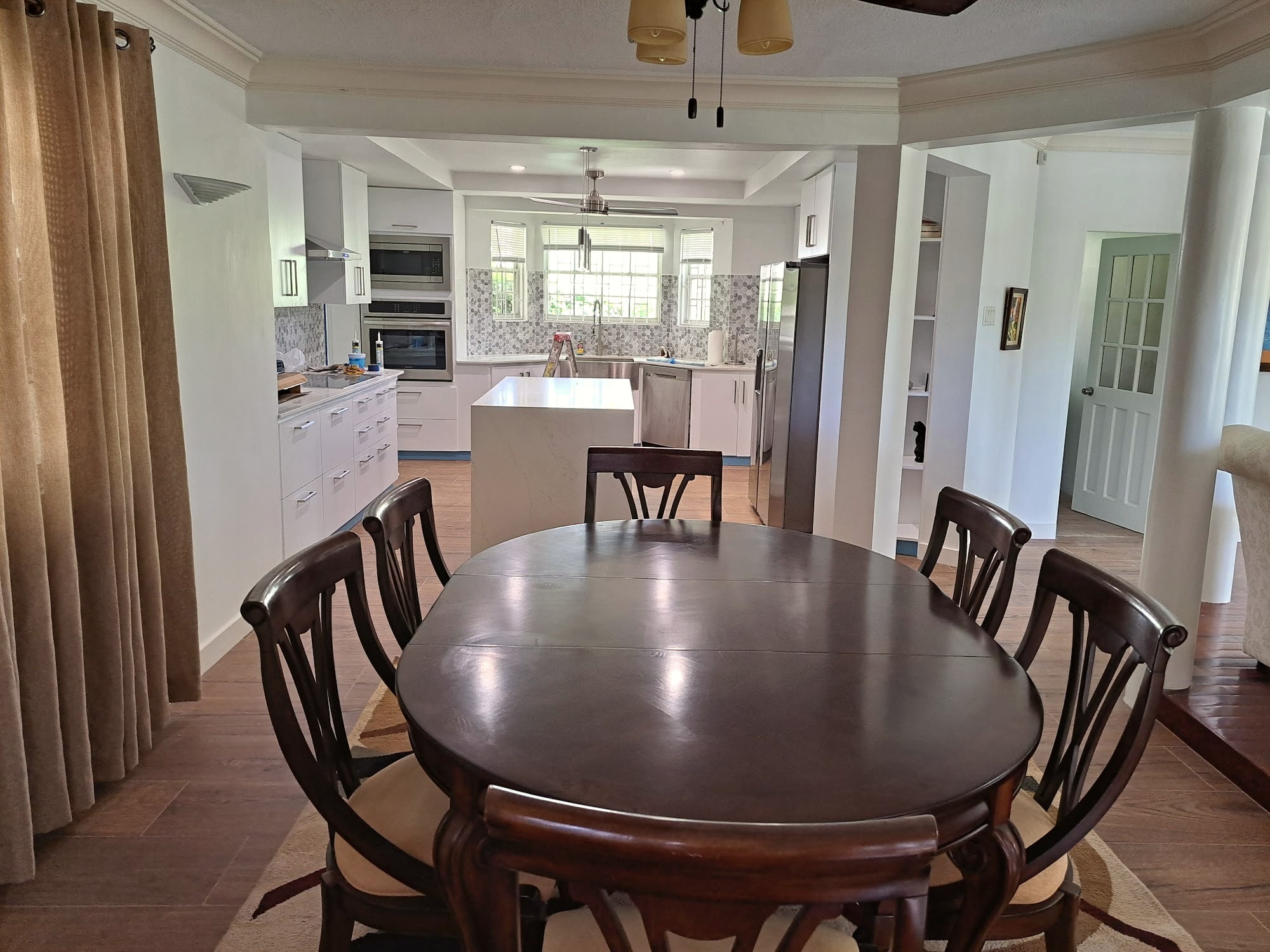 Open-plan dining area adjoining the renovated kitchen, with oval wood dining table