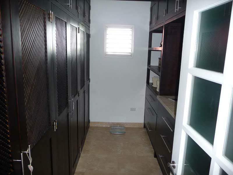 Walk-in dressing room with dark timber cabinetry