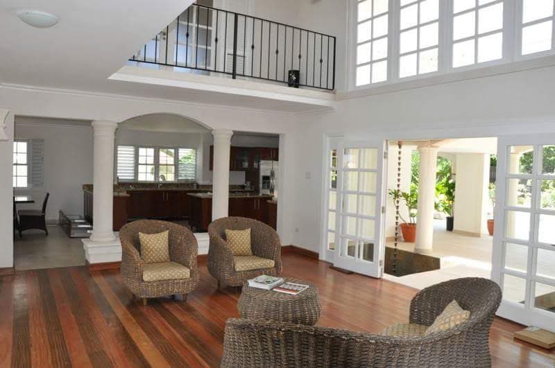 Living room with double-height mezzanine and wicker furniture