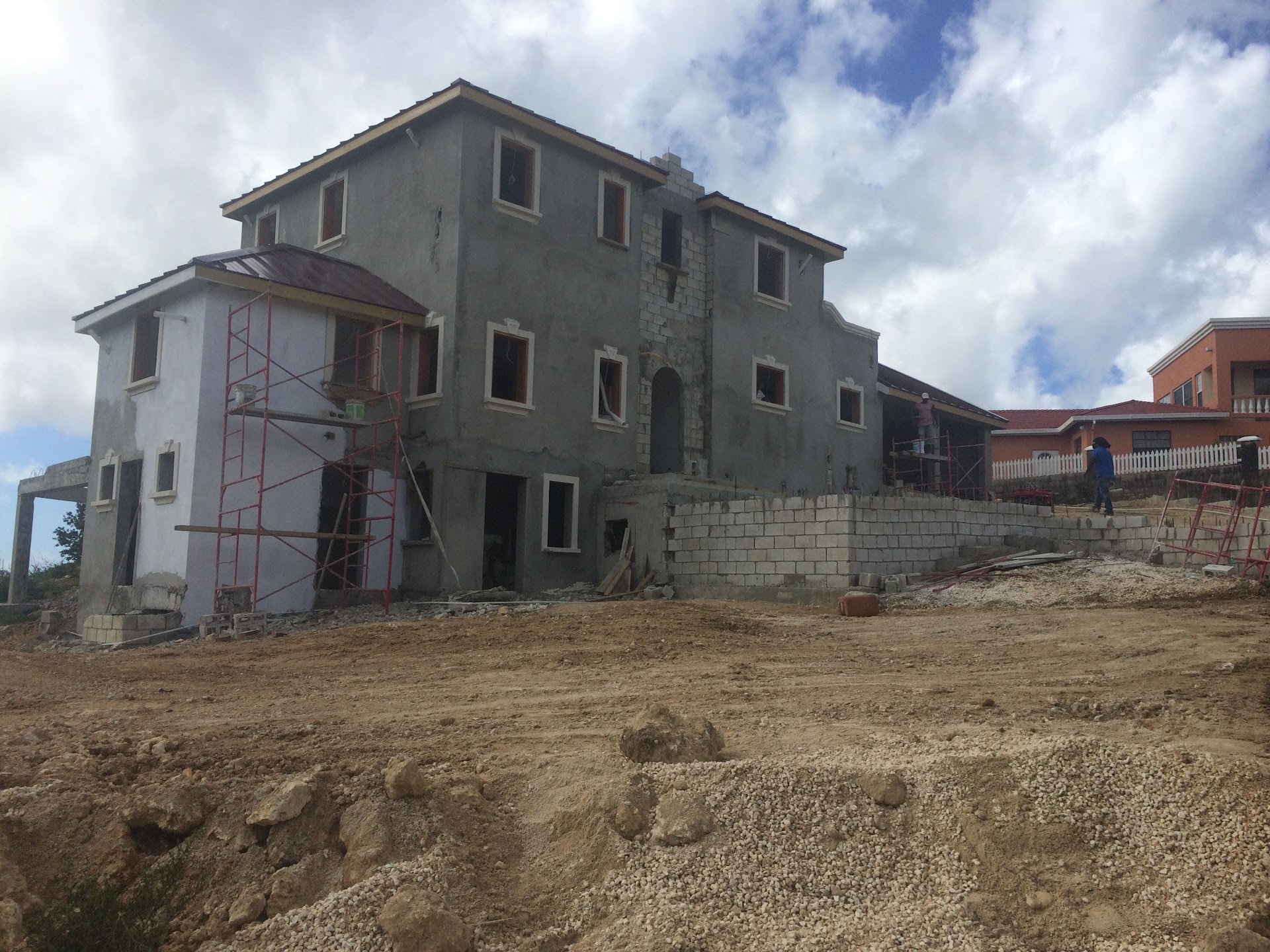 Two-storey residence under construction with scaffolding and render in progress